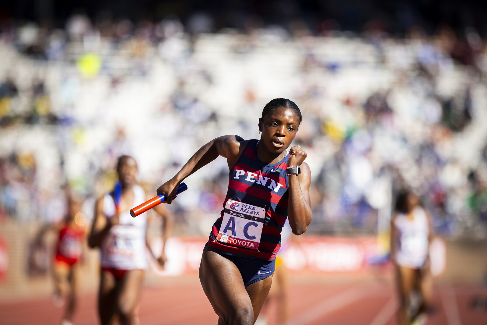 penn relay race with runner holding baton